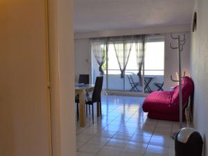 a living room with a red couch and a table at Appartement Collioure, 3 pièces, 6 personnes - FR-1-225-705 in Collioure