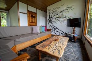 Una sala de estar con un sofá y un televisor. en Natural Wonders House, en Monteverde