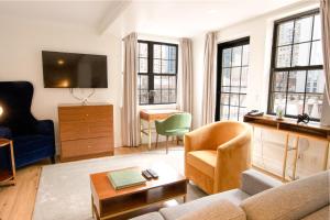 a living room with a couch and a tv at Hotel Scherman in New York