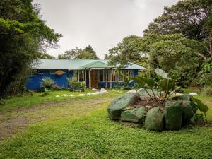una casa azul con rocas delante de ella en Natural Wonders House, en Monteverde