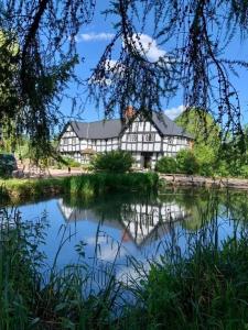 a large building sitting next to a lake at The Vauld, 2 bedroom suite with Bed and Breakfast in Bodenham