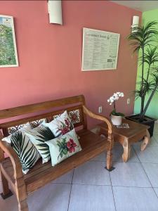 a wooden bench with pillows on it next to a wall at Imperial Suítes by Prado in Petrópolis
