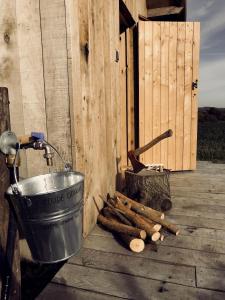 Ein Topf und ein Eimer und ein Haufen Holz in der Unterkunft Kompas gîte in Ellezelles