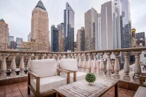 two chairs and a table on a balcony with a city skyline at Hotel Scherman in New York
