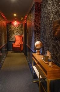 a hallway with a red chair and a table at Hotel Scherman in New York