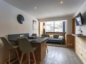 a living room with a table and chairs and a couch at appartement 4 personnes, très cosy et fonctionnel, 2 chambres séparées, vue montagne, exposé nord, départ ski aux pieds - FR-1-545-13 in Val Thorens