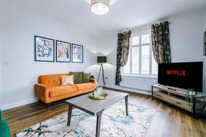 a living room with a couch and a tv at Parkview Place Serviced Apartment in Coventry