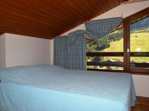 a bedroom with a bed and a window with a view at Appartement Le Grand-Bornand, 3 pièces, 6 personnes - FR-1-241-229 in Le Grand-Bornand