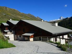 a large wooden barn with a driveway next to a mountain at Appartement Le Grand-Bornand, 3 pièces, 6 personnes - FR-1-241-229 in Le Grand-Bornand