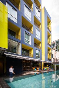 a building with a swimming pool in front of it at LiT BANGKOK Residence - SHA Extra Plus in Bangkok