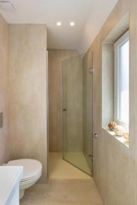 La salle de bains est pourvue d'une douche, de toilettes et d'une fenêtre. dans l'établissement Erkel Rooftop Suites, à Budapest