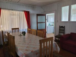 cocina y comedor con mesa y sillas en Hospedaje Palena en Ancud
