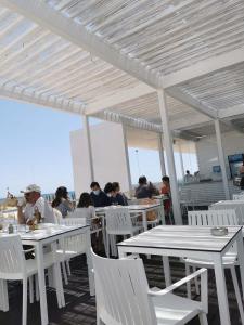 un gruppo di persone seduti ai tavoli sulla spiaggia di Luxury 3 bedroom Villa with Private Pool a Cabanas de Tavira