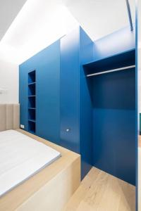 a bedroom with blue walls and a bed at Apartament Blue City - Hanza Tower in Szczecin