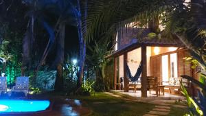 a villa with a swimming pool at night at Refúgio Arraial - Casa em Arraial d'ajuda in Arraial d'Ajuda
