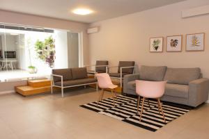 uma sala de espera com um sofá e cadeiras cor-de-rosa em 360 Av Ipiranga em São Paulo
