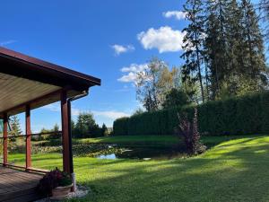 a yard with a gazebo and a pond at Rojaus kampelis. Kaimo turizmas in Gudžiūnai