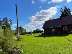 a house in a yard with a green lawn at Rojaus kampelis. Kaimo turizmas in Gudžiūnai +38 photos