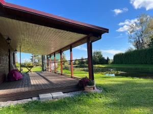 a porch of a house with a wooden deck at Rojaus kampelis. Kaimo turizmas in Gudžiūnai