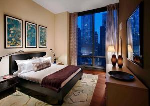 una camera con un grande letto e una grande finestra di Lovely 3 Bedroom Condo near Central Park a New York