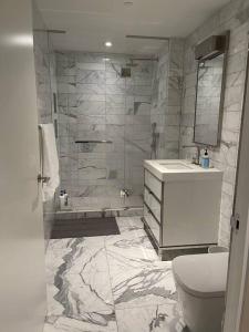 a bathroom with a shower and a toilet and a sink at Lovely 3 Bedroom Condo near Central Park in New York