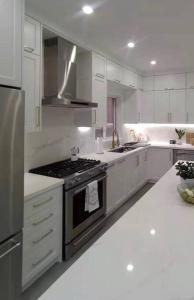 una cucina con armadi bianchi e piano cottura di Lovely 3 Bedroom Condo near Central Park a New York