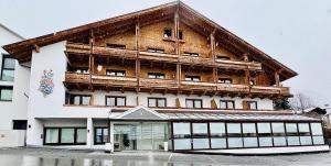 un gran edificio de madera con muchas ventanas en Hotel Montana, en Telfes im Stubai