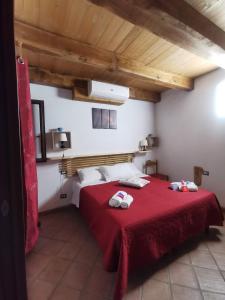 リングアグロッサにあるEtna Paradise Locazione Turisticaのベッドルーム1室(赤いベッド1台、タオル付)