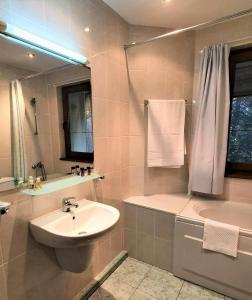 a bathroom with a sink and a toilet and a tub at Kokiche Private Apartments in Borovets
