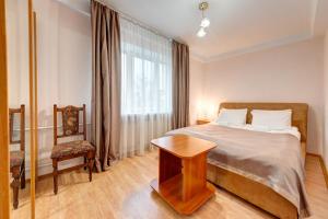 a bedroom with a bed and a table and a window at Holosiyvsky Hotel in Kyiv