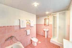 a pink bathroom with a toilet and a sink at Holosiyvsky Hotel in Kyiv