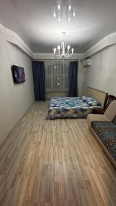 a bedroom with a bed and a chandelier at Однокомнатная квартира in Aktobe