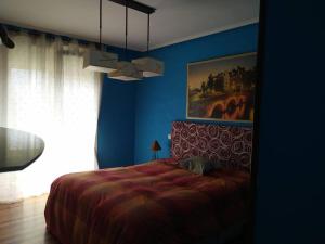 1 dormitorio con cama y pared azul en TUS VACACIONES EN SANTANDER, en Santander