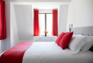a bedroom with a large bed with red curtains at Cameo Hotel and Suites in Halifax