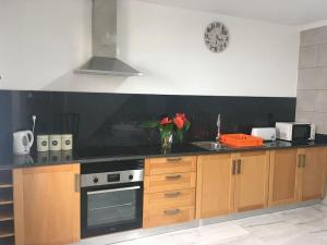 eine Küche mit Holzschränken und einer schwarzen Arbeitsplatte in der Unterkunft Casa dos Avós Domingos & Matilde in Estreito da Calheta + 36 Fotos