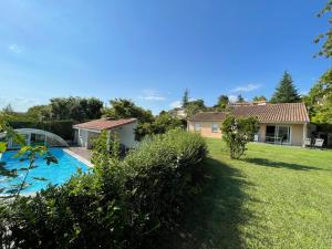 einen Blick auf den Hinterhof eines Hauses mit Pool in der Unterkunft Très belle villa avec piscine dans la Drôme in Romans-sur-Isère