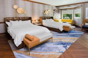 una camera d'albergo con due letti e un divano di Chateau Merrimack Hotel & Spa a Tyngsboro