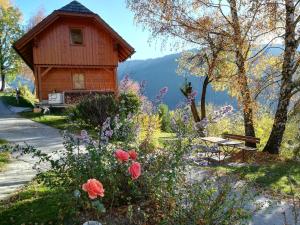 eine Holzhütte mit einem Tisch und Blumen davor in der Unterkunft Bio- Erlebnis-Bauernhof-Thonnerhof in Aigen im Ennstal