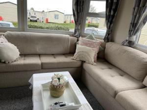 un soggiorno con divano e tavolo di Trecco Bay Porthcawl Caravan 8 berth PALMS 4 a Newton