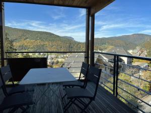 a table and chairs on a balcony with a view at Appartement fonctionnel avec balcon, à 10 min du centre, parking gratuit, idéal pour 5 personnes - FR-1-548-3 in Villard-de-Lans
