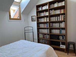 維拉爾－德朗的住宿－Appartement Villard-de-Lans, 3 pièces, 5 personnes - FR-1-548-3，一间卧室,书架上摆放着书籍
