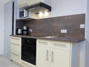 a kitchen with white cabinets and a black stove at Maison Villard-de-Lans, 4 pièces, 8 personnes - FR-1-548-5 in Villard-de-Lans