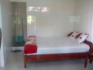 Dormitorio pequeño con cama y ducha en Hai Anh Guesthouse en Phu Quoc