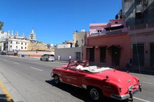 a red car parked on the side of a street at Casa Sayli Appartement 1 in Havana