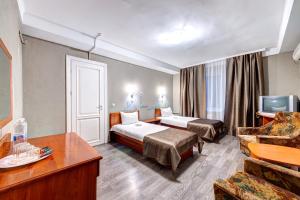 Habitación de hotel con 2 camas y sofá en Holosiyvsky Hotel en Kiev