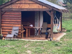 a wooden cabin with a table and chairs in the grass at Apartmán Chiarita in Nemšová