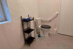 Un baño con un inodoro con un estante al lado. en La Bergerie de Bénéauville 7 personnes, en Bavent 19 fotos más