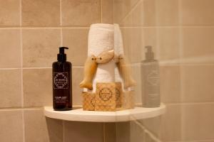 a shelf with a towel and a bottle of soap at Port Antic Ciutadella by My Rooms Hotels in Ciutadella