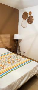 ein Schlafzimmer mit einem Bett und einer Lampe und Platten an der Wand in der Unterkunft Les docks libres sud in Marseille