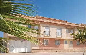 ein Gebäude mit einer Palme davor in der Unterkunft Cozy Apartment In Los Alcazares in Los Alcázares